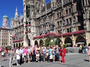 Gruppe strahlender Touristen vor Neuem Rathaus München Marienplatz