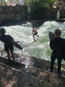 Im Neoprenanzug anstehen, um auf der Eisbachwelle zu surfen