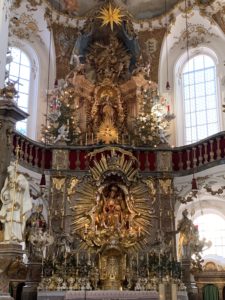 Wer die Andechser Wallfahrts-Kirche auf dem Heiligen Berg betritt, den empfängt ein lichter barocker Hochaltar mit Aufstellung der Seitenaltäre. Die Lichtfülle dieses Rokoko-Juwels ist atemberaubend schön.