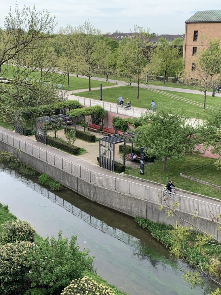 Aus der Vogelperspektive sieht man das Gesamtkunstwerk Petuelpark auf 7,4 Hektar. Im Zentrum das Café-Haus, Am Horizont im Westen die Olympiapressestadt. Im Osten Blick auf die Birkenallee mit Tunneleinfahrt Ecke Ingolstädter-/ Schenkendorfstraße